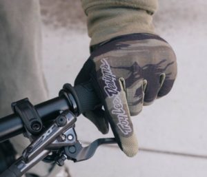 mountain biker with troy lee designs gloves holding a handle bar