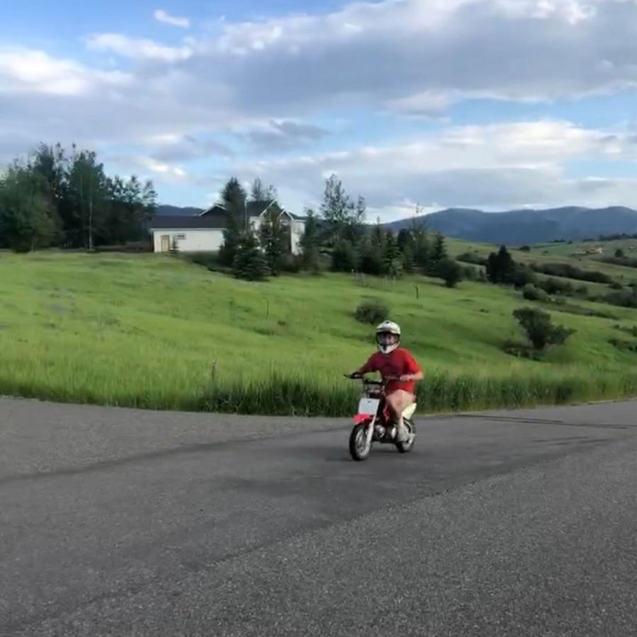 owenhouse cycling team member oliver goodell on a mini motorcycle