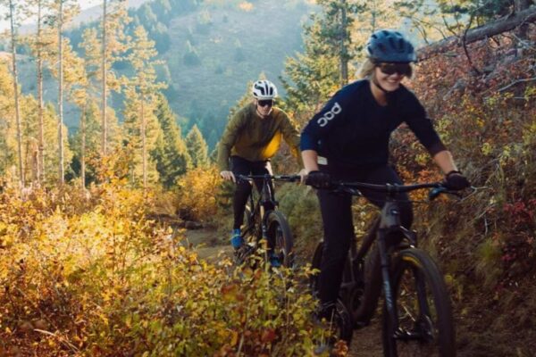 female and male riding mountain bikes in the fall in bozeman