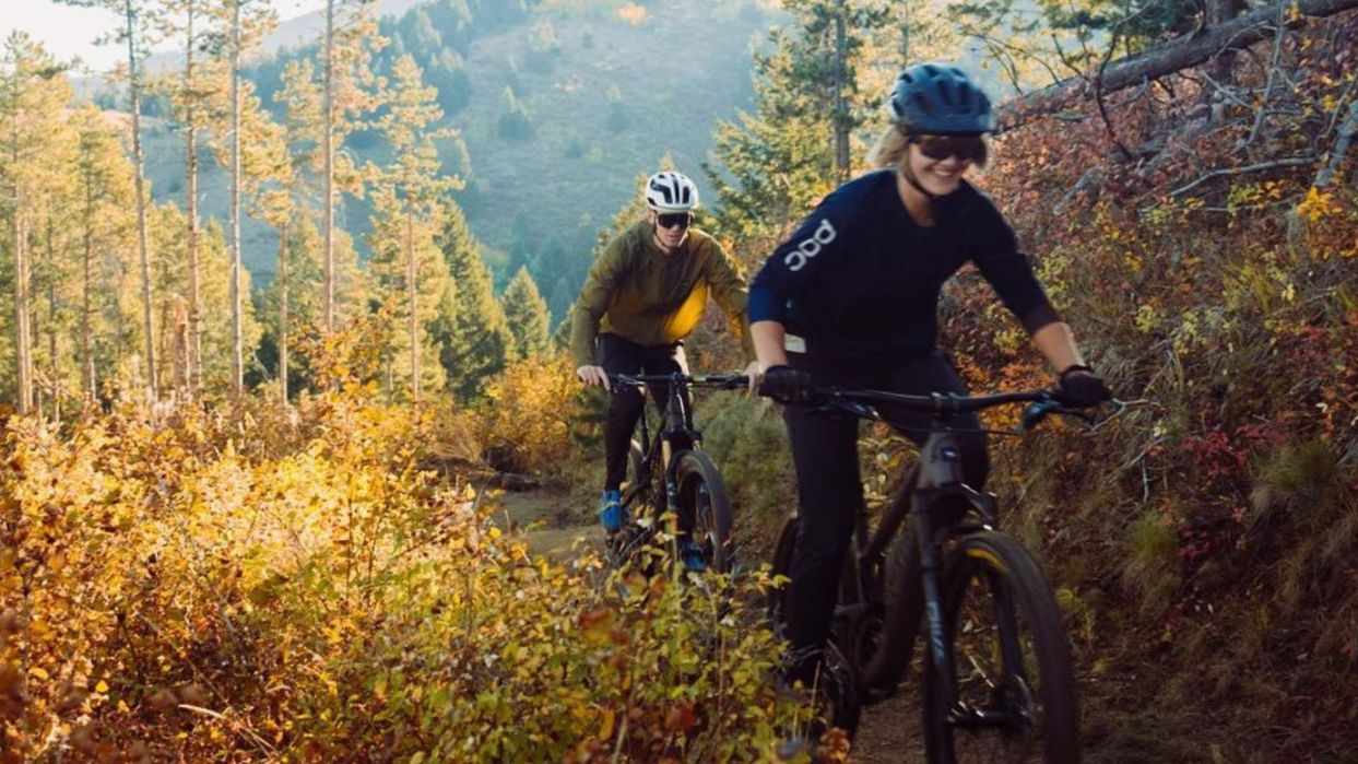 female and male riding mountain bikes in the fall in bozeman