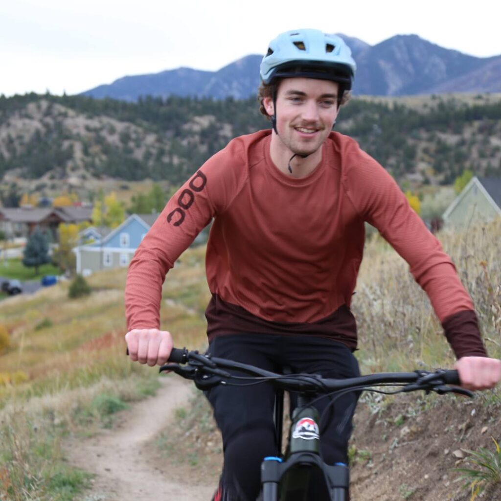 happy owenhouse employee riding a rocky mountain bike on a trail in fall weather
