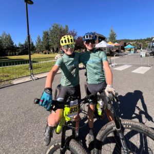 two older kids at a mountain bike racing wearing matching kits